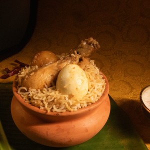 Hot and fresh chicken biryani ready to serve with yellow mustard on the side